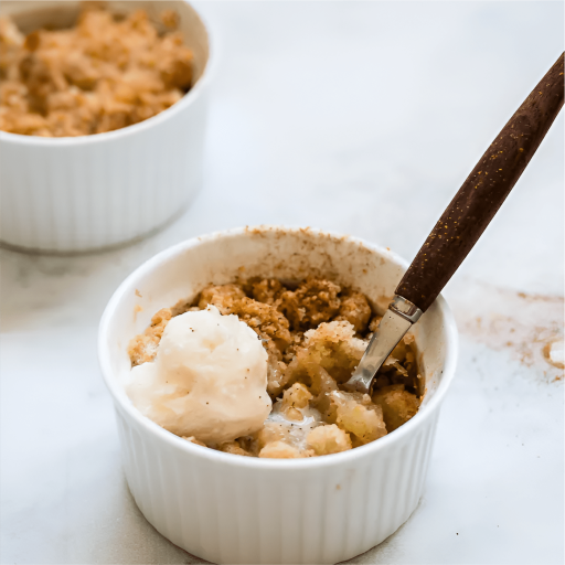 A dozen individual Bakendales apple crumble pots, each with a golden-brown crumble topping.