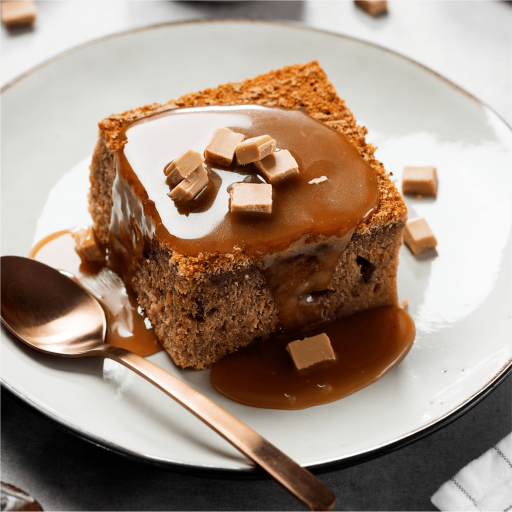 A warm Bakendales sticky toffee pudding, served in a platter, with a rich toffee sauce