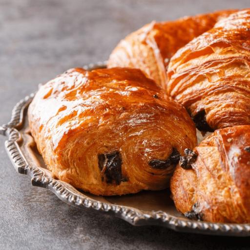 A golden-brown Bakendales Pain au Chocolat, with a rich chocolate center and flaky layers