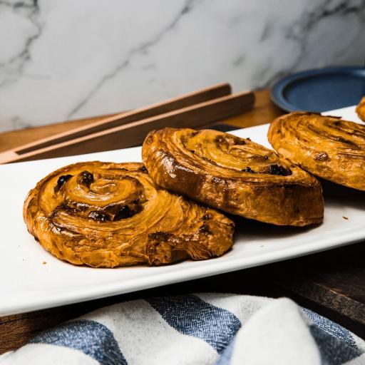 Platter of full-size Bakendales Pain aux Raisins, with a spiral of pastry and raisins visible
